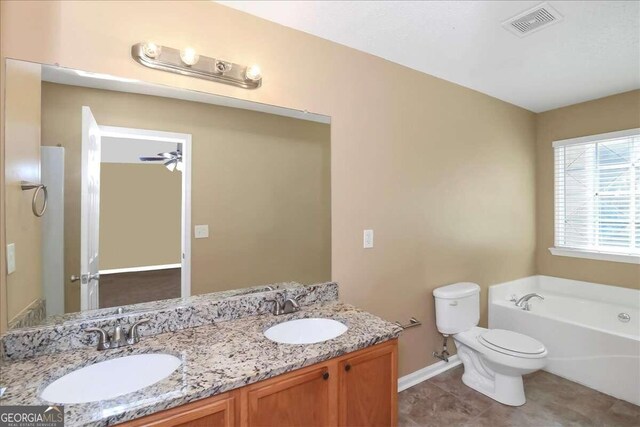 bathroom featuring ceiling fan, double sink vanity, a tub to relax in, toilet, and tile patterned flooring