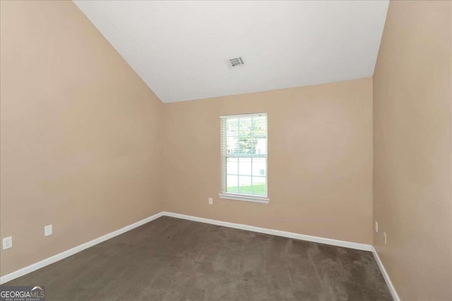 empty room featuring vaulted ceiling and carpet flooring