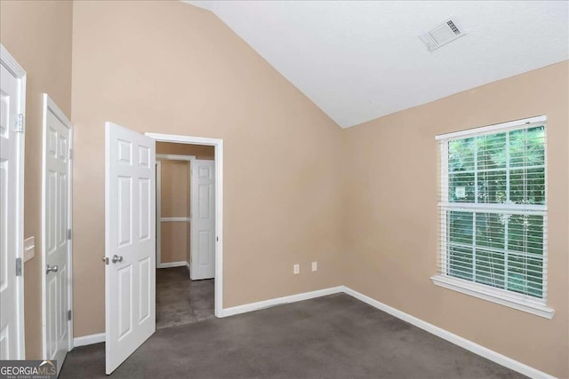 unfurnished bedroom featuring lofted ceiling and carpet