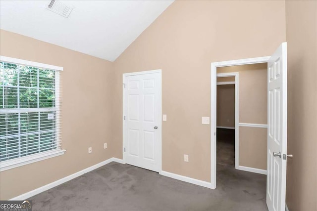 unfurnished bedroom featuring light carpet and vaulted ceiling