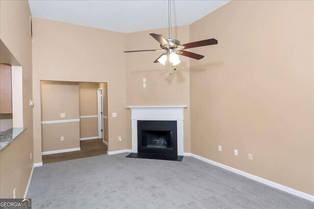 unfurnished living room featuring ceiling fan, high vaulted ceiling, and carpet