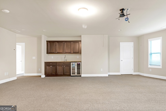 unfurnished living room with light colored carpet and beverage cooler