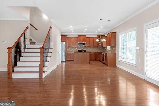 kitchen with tasteful backsplash, stainless steel appliances, hardwood / wood-style flooring, and pendant lighting