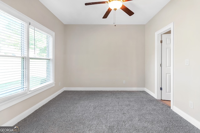 empty room featuring ceiling fan, carpet flooring, and a wealth of natural light