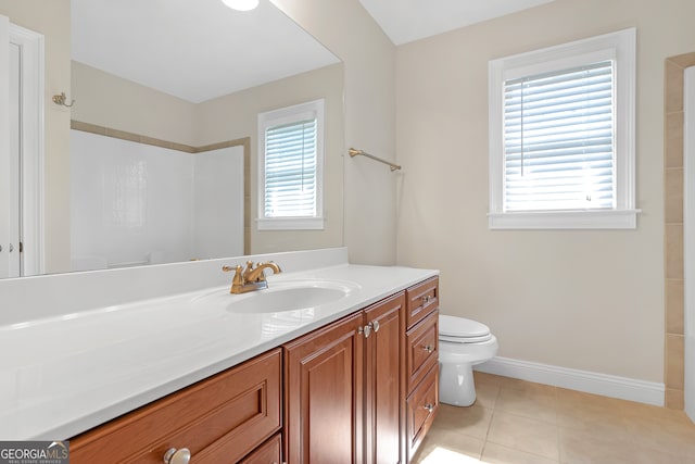 bathroom featuring toilet, tile patterned floors, vanity, and a healthy amount of sunlight