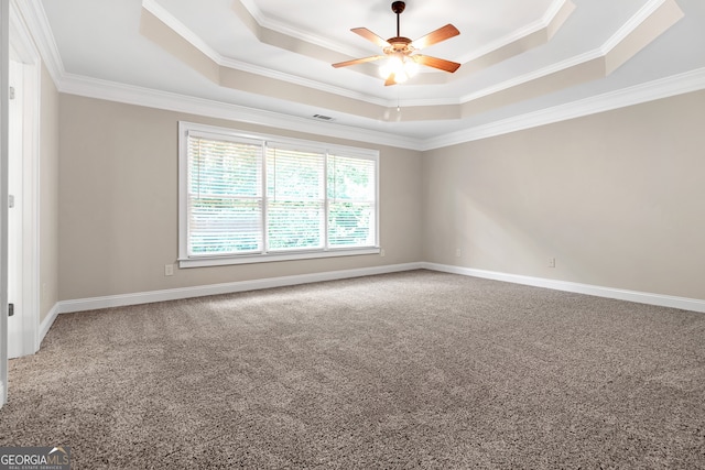 carpeted empty room with a tray ceiling, ornamental molding, and ceiling fan