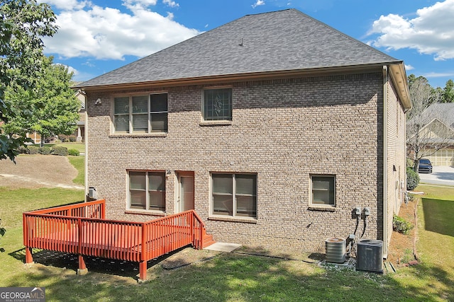 rear view of property with a lawn, a deck, and central air condition unit