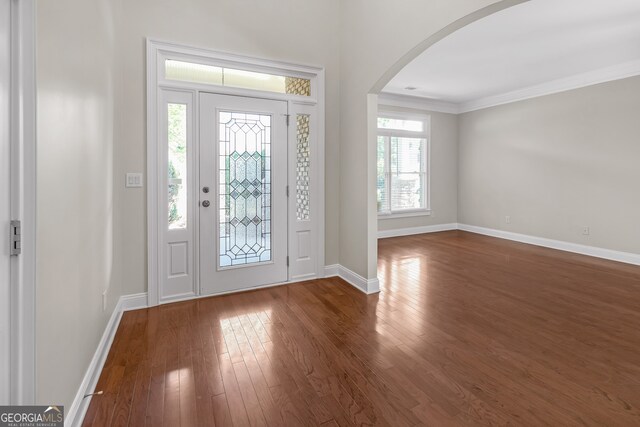 entrance foyer featuring crown molding, plenty of natural light, and dark hardwood / wood-style floors