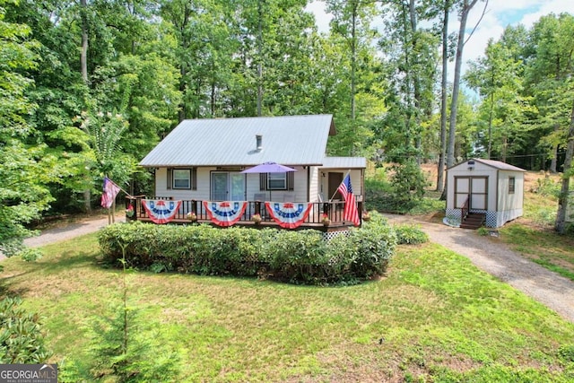 view of front of home featuring a front yard, a storage unit, and a wooden deck