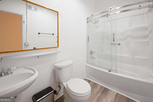 full bathroom featuring toilet, bath / shower combo with glass door, sink, and wood-type flooring