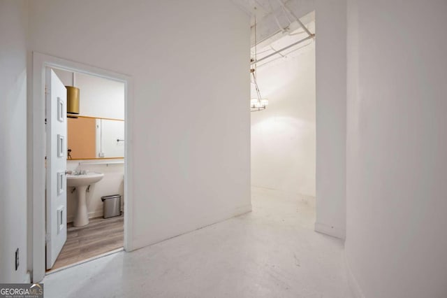 hallway featuring concrete floors and sink