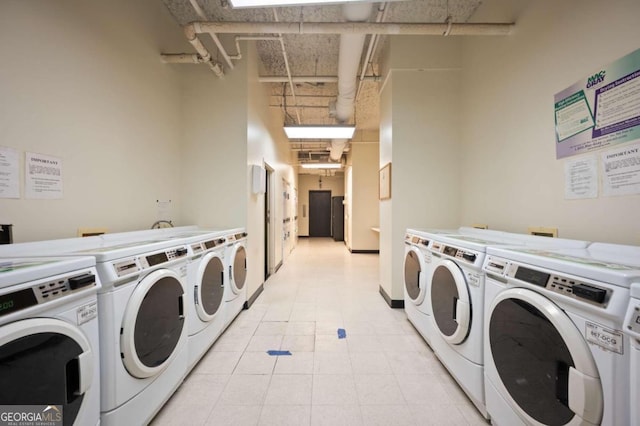 washroom featuring washer and dryer, light tile patterned flooring, and a towering ceiling