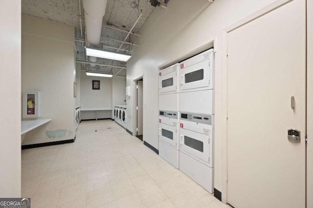 interior space with washer and dryer, stacked washer and dryer, and light tile patterned floors