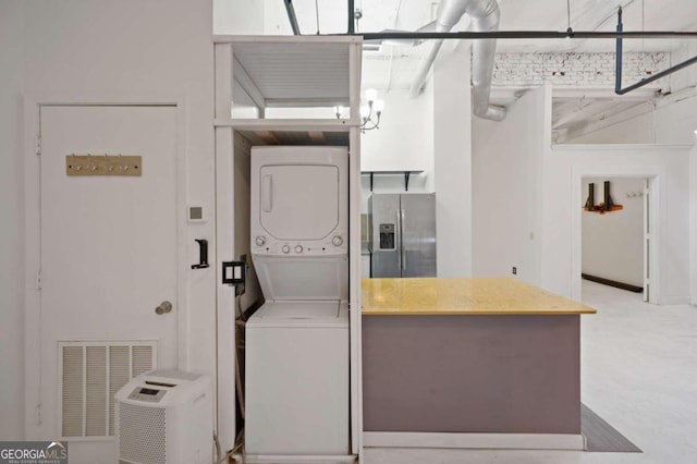 clothes washing area with stacked washer and clothes dryer