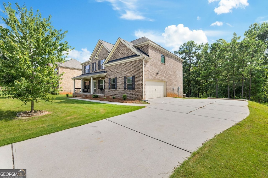 view of front of property with a garage, a front lawn, concrete driveway, and brick siding