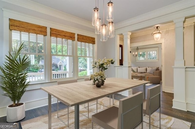 dining space with ornate columns, crown molding, plenty of natural light, and dark hardwood / wood-style flooring