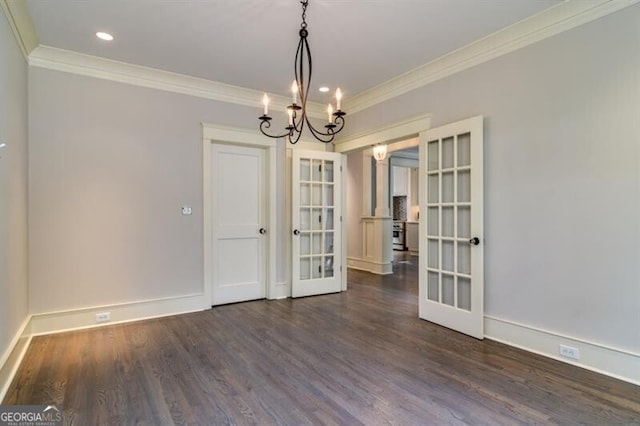 unfurnished dining area featuring dark hardwood / wood-style floors, crown molding, french doors, and an inviting chandelier