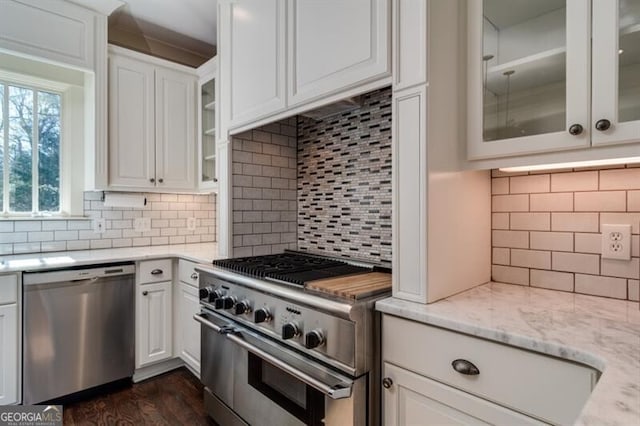 kitchen with dark hardwood / wood-style flooring, white cabinetry, backsplash, and appliances with stainless steel finishes