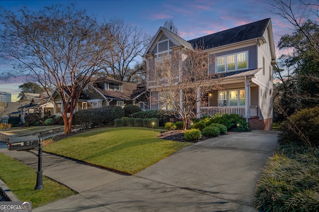 view of front of house with covered porch and a yard