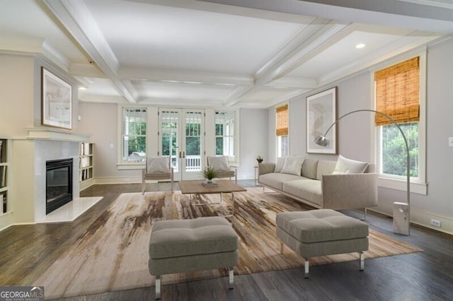 living room featuring a wealth of natural light, coffered ceiling, dark hardwood / wood-style flooring, and a premium fireplace