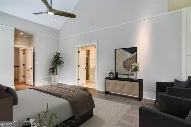 bedroom featuring ceiling fan, high vaulted ceiling, ensuite bath, and wood-type flooring