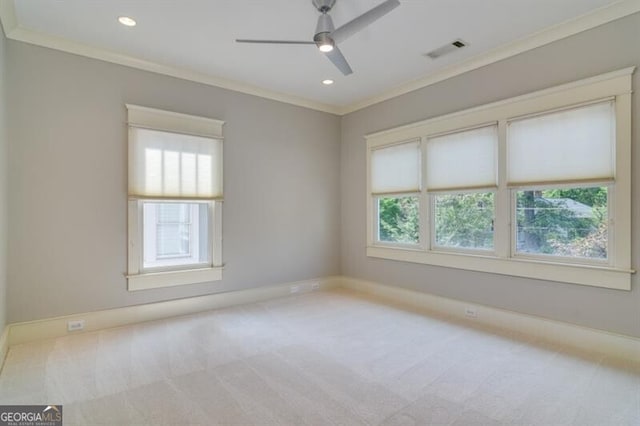 carpeted spare room featuring ceiling fan and crown molding