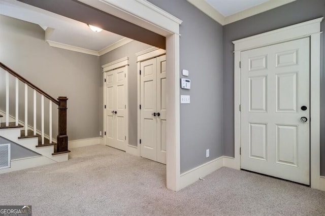 entrance foyer featuring crown molding and light colored carpet