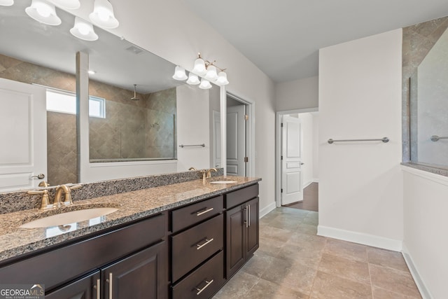 bathroom with tiled shower and vanity