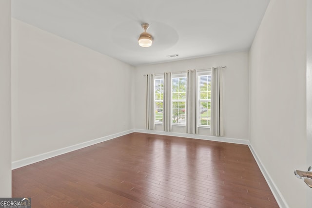 empty room featuring ceiling fan and dark wood-type flooring