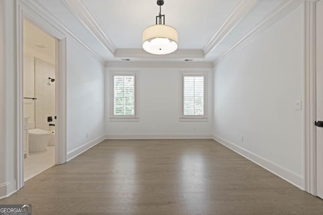 interior space featuring hardwood / wood-style flooring, a raised ceiling, and ornamental molding