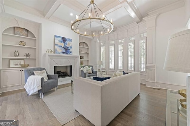 living room with light hardwood / wood-style floors, coffered ceiling, built in shelves, and a fireplace