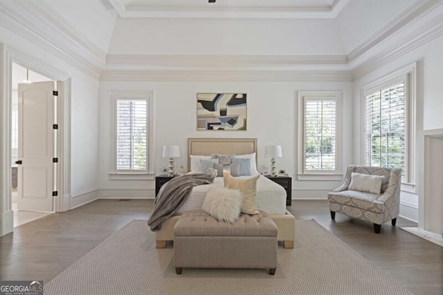 bedroom with crown molding, a raised ceiling, and hardwood / wood-style flooring