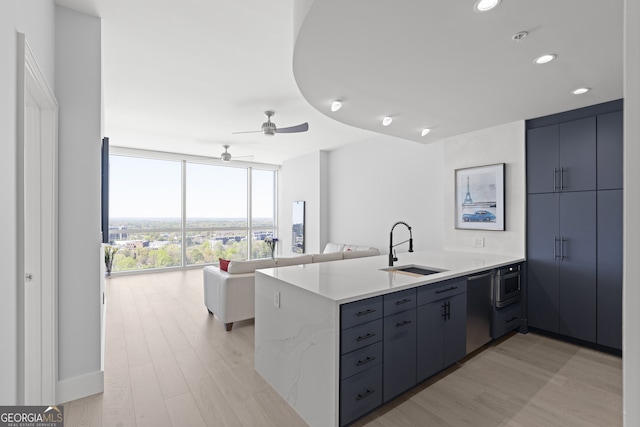 kitchen with sink, dishwashing machine, kitchen peninsula, ceiling fan, and floor to ceiling windows