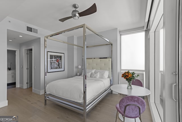 bedroom featuring visible vents, light wood-style flooring, baseboards, and ceiling fan