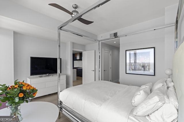 bedroom featuring a ceiling fan, wood finished floors, and visible vents