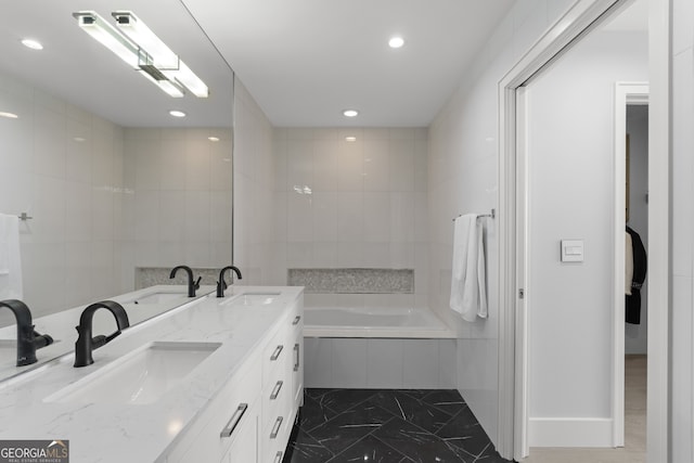 bathroom featuring double sink vanity, tiled tub, and tile patterned floors