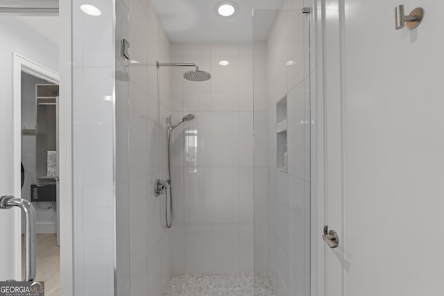 bathroom with a shower stall and wood finished floors