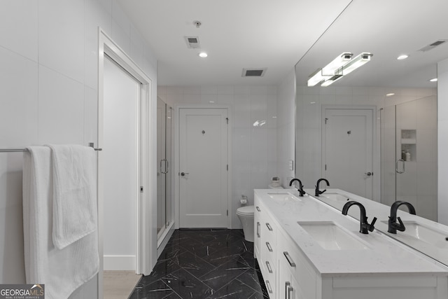 bathroom featuring toilet, dual vanity, walk in shower, and tile patterned floors