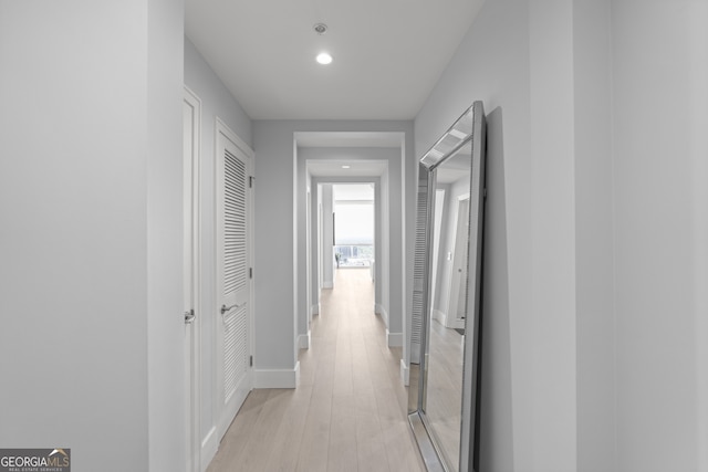 hall featuring recessed lighting, baseboards, and light wood-style floors