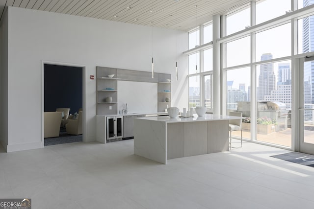 kitchen featuring a city view, open shelves, a sink, a wall of windows, and a towering ceiling