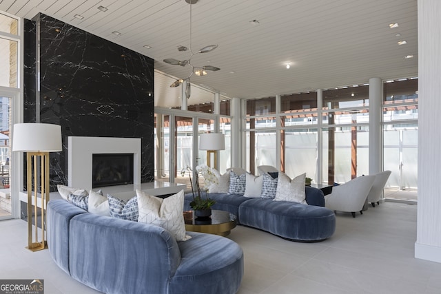 living room featuring tile patterned flooring, floor to ceiling windows, and a premium fireplace