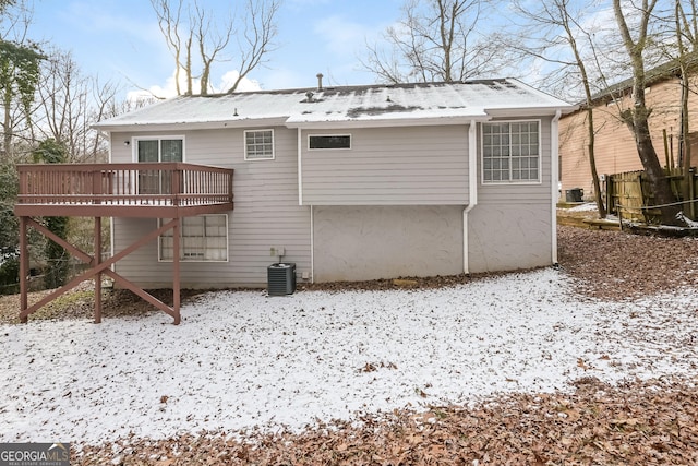 snow covered house with a wooden deck and central air condition unit