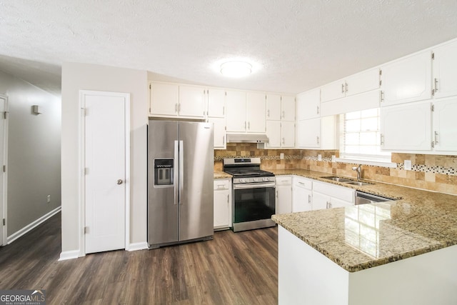 kitchen with light stone counters, white cabinetry, and stainless steel appliances