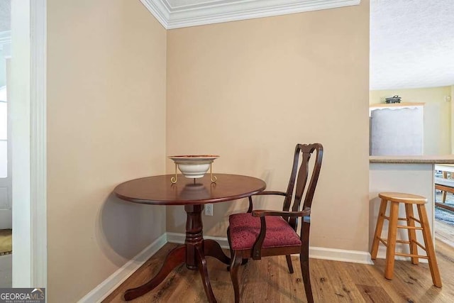 dining room featuring ornamental molding and light hardwood / wood-style flooring