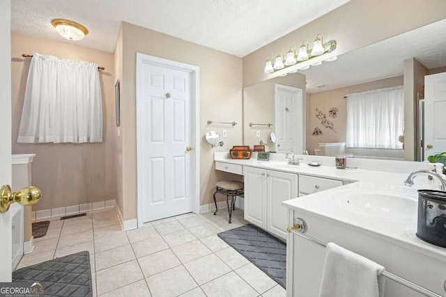 bathroom with tile patterned flooring, a textured ceiling, and vanity