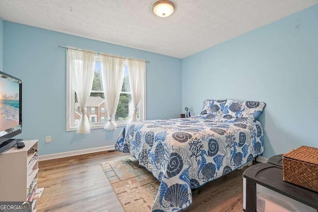 bedroom with a textured ceiling and hardwood / wood-style flooring