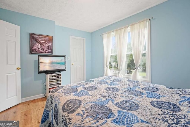 bedroom with wood-type flooring and a textured ceiling