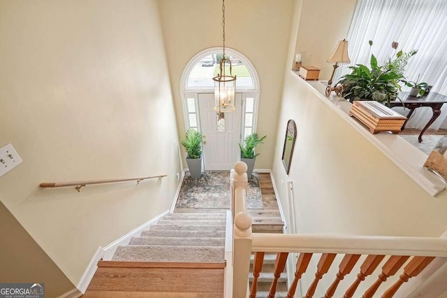 foyer featuring a notable chandelier, hardwood / wood-style floors, and a high ceiling