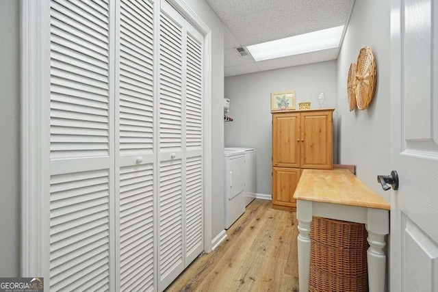 clothes washing area with light wood-type flooring and washing machine and dryer