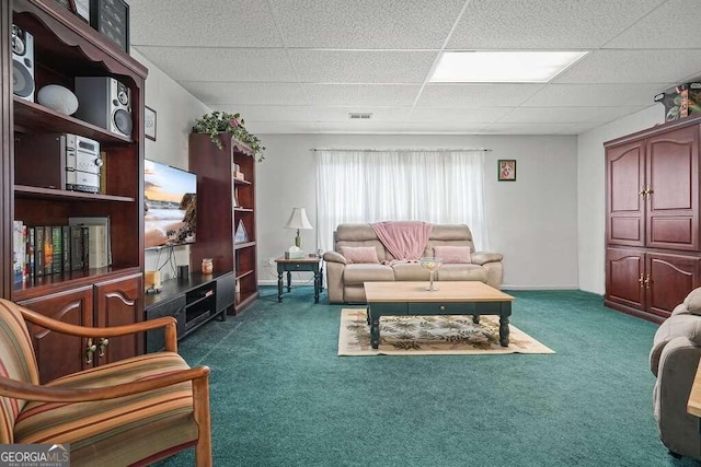 living room with dark carpet and a drop ceiling